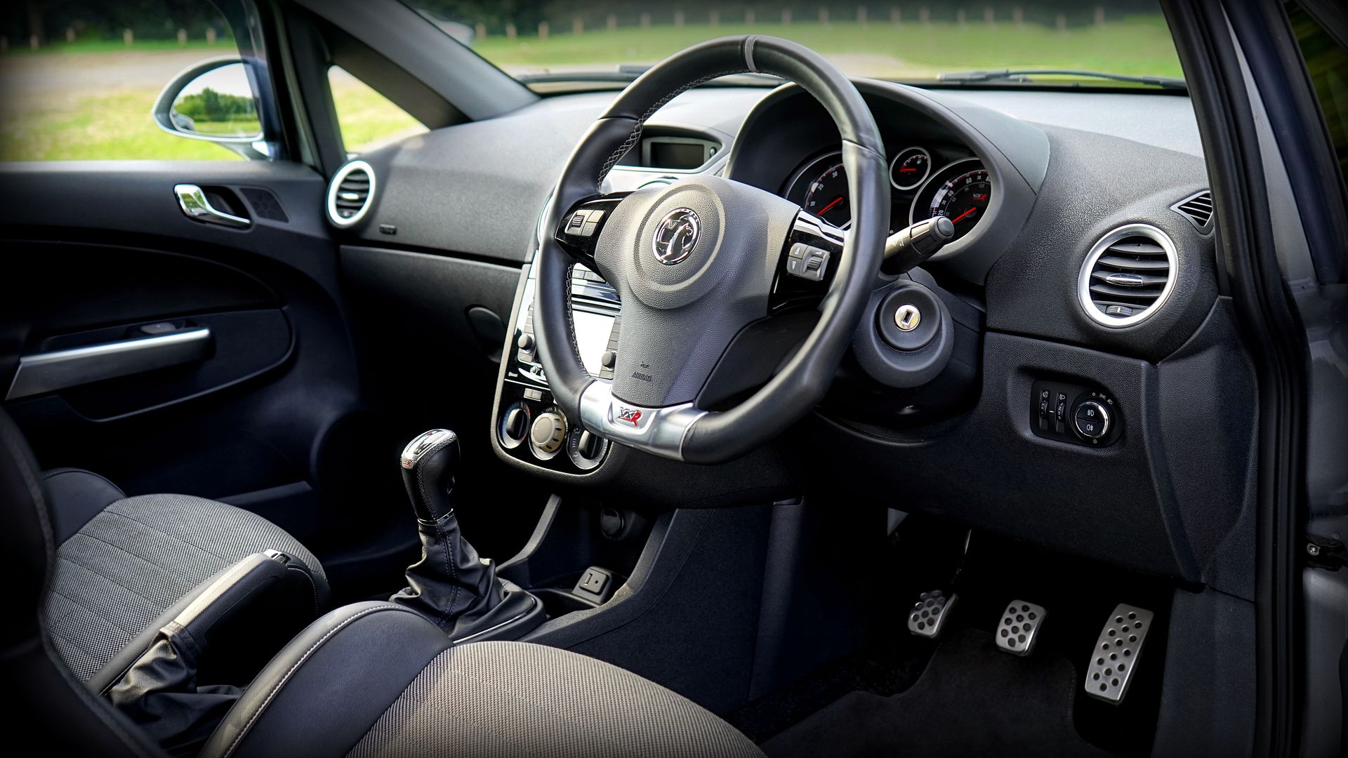 Detailed view of a modern car's interior featuring the steering wheel and dashboard.